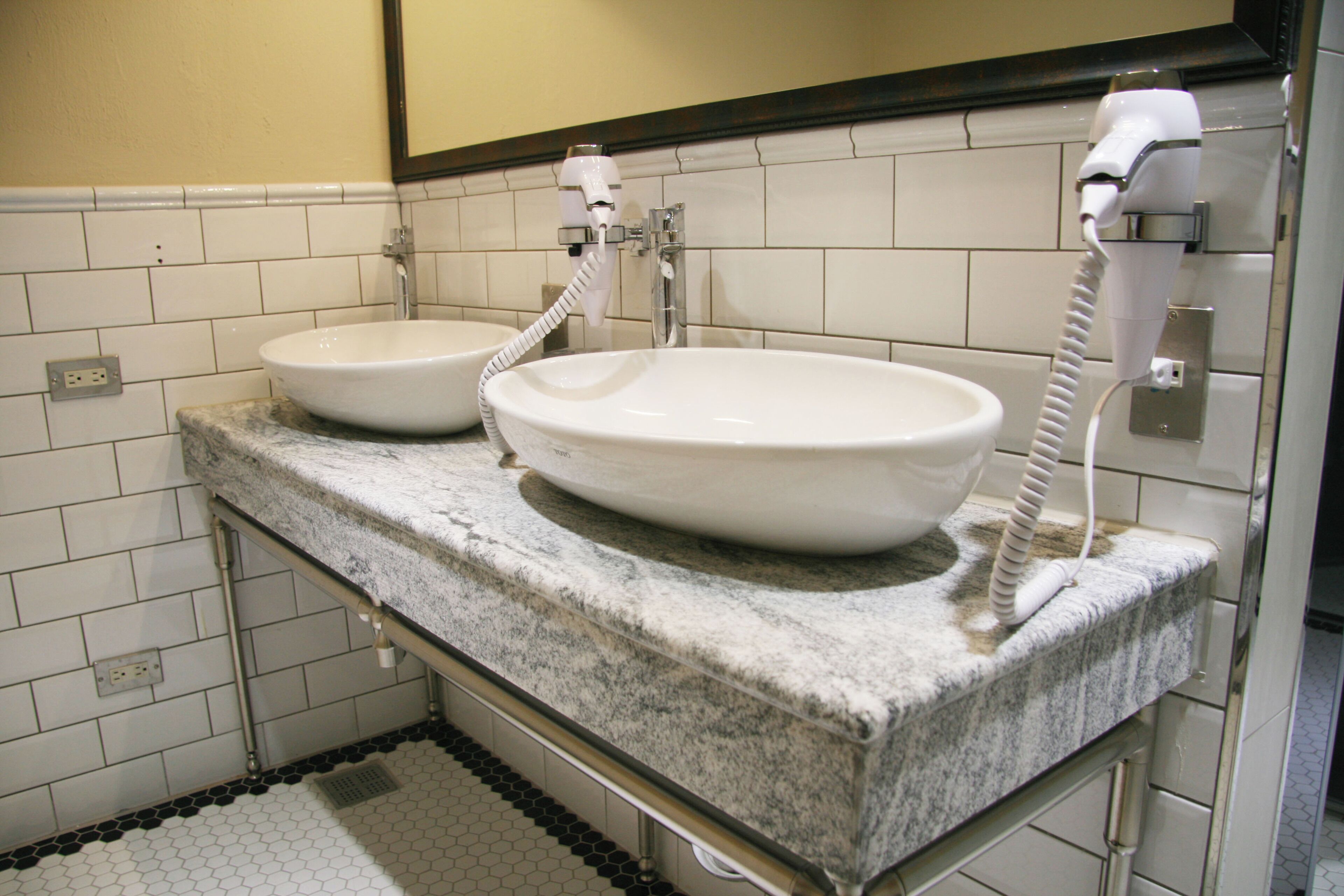 Une salle de bain avec deux lavabos, un miroir et un porte-serviettes.