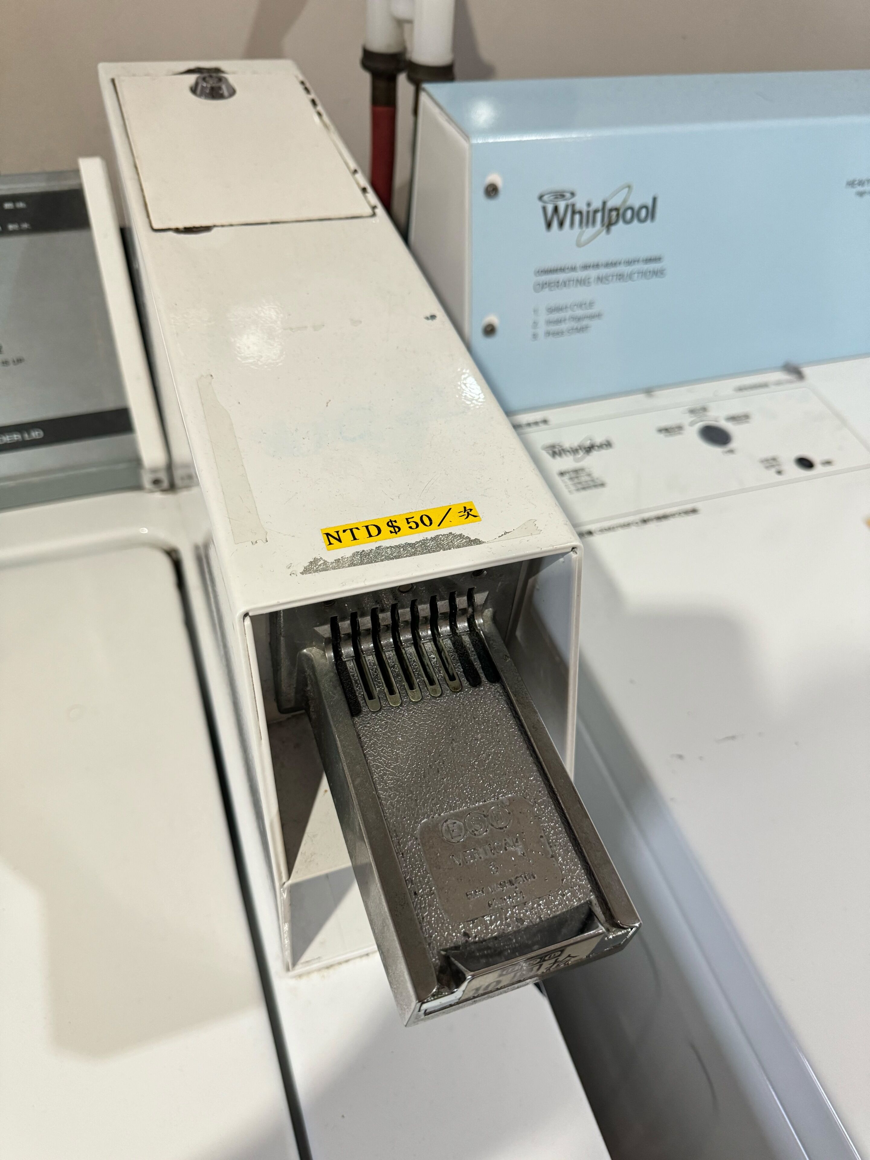 A Whirlpool appliance with a metal component and a yellow sticker.