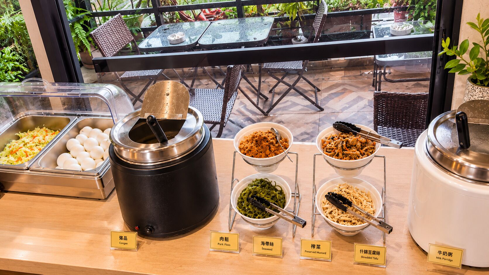 Een buffet met diverse gerechten en labels in een restaurant.