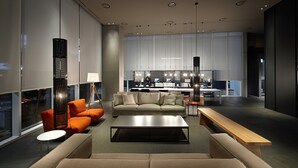 Una sala moderna con sofá, mesa de centro y un comedor con banco.