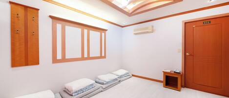 A hotel room with a bed, a wardrobe, a window, and a door.