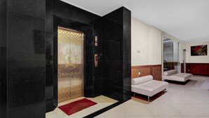 A hotel lobby with a reception desk, a red carpet, and a seating area with sofas. - Palette Grand Sae Boutique Hotel (Surakarta)
