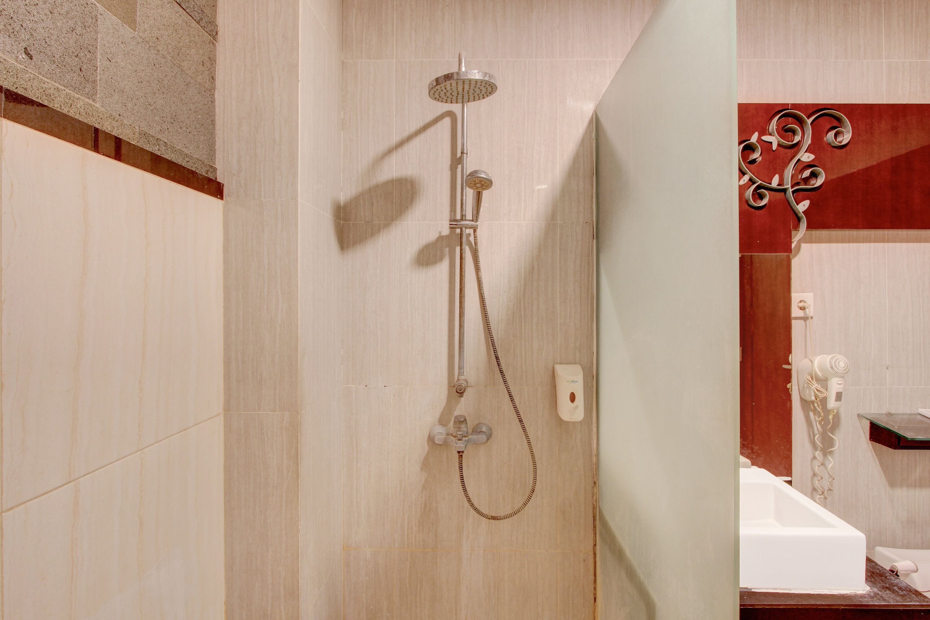 A shower with a handheld showerhead and a handheld dryer.