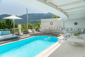 Outdoor pool, a rooftop pool, pool umbrellas, pool loungers
