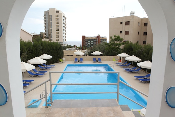 Piscine extérieure, parasols de plage, chaises longues