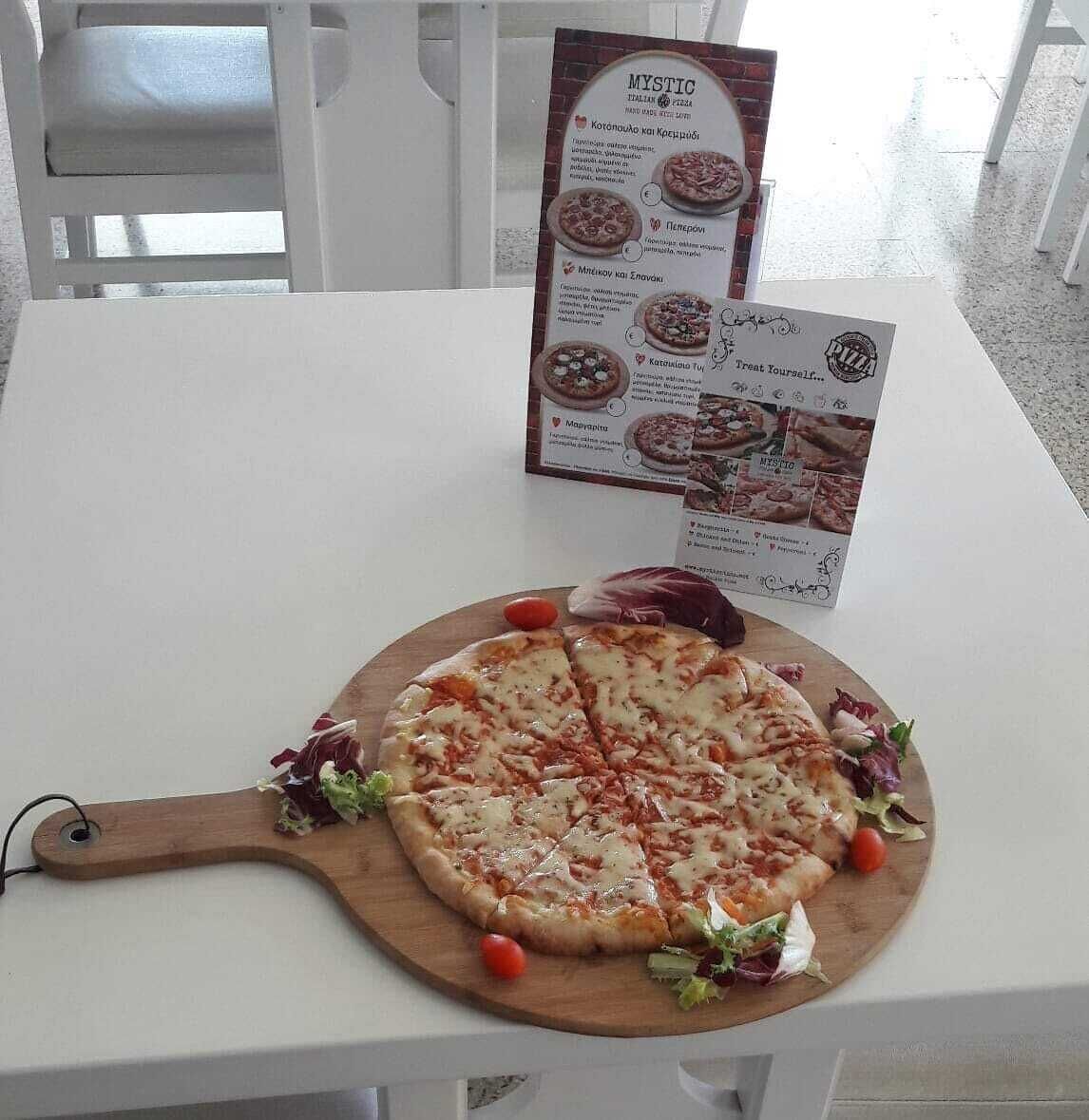 A pizza on a wooden board with a menu in the background.