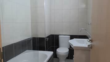 A bathroom with a bathtub, toilet, and sink.