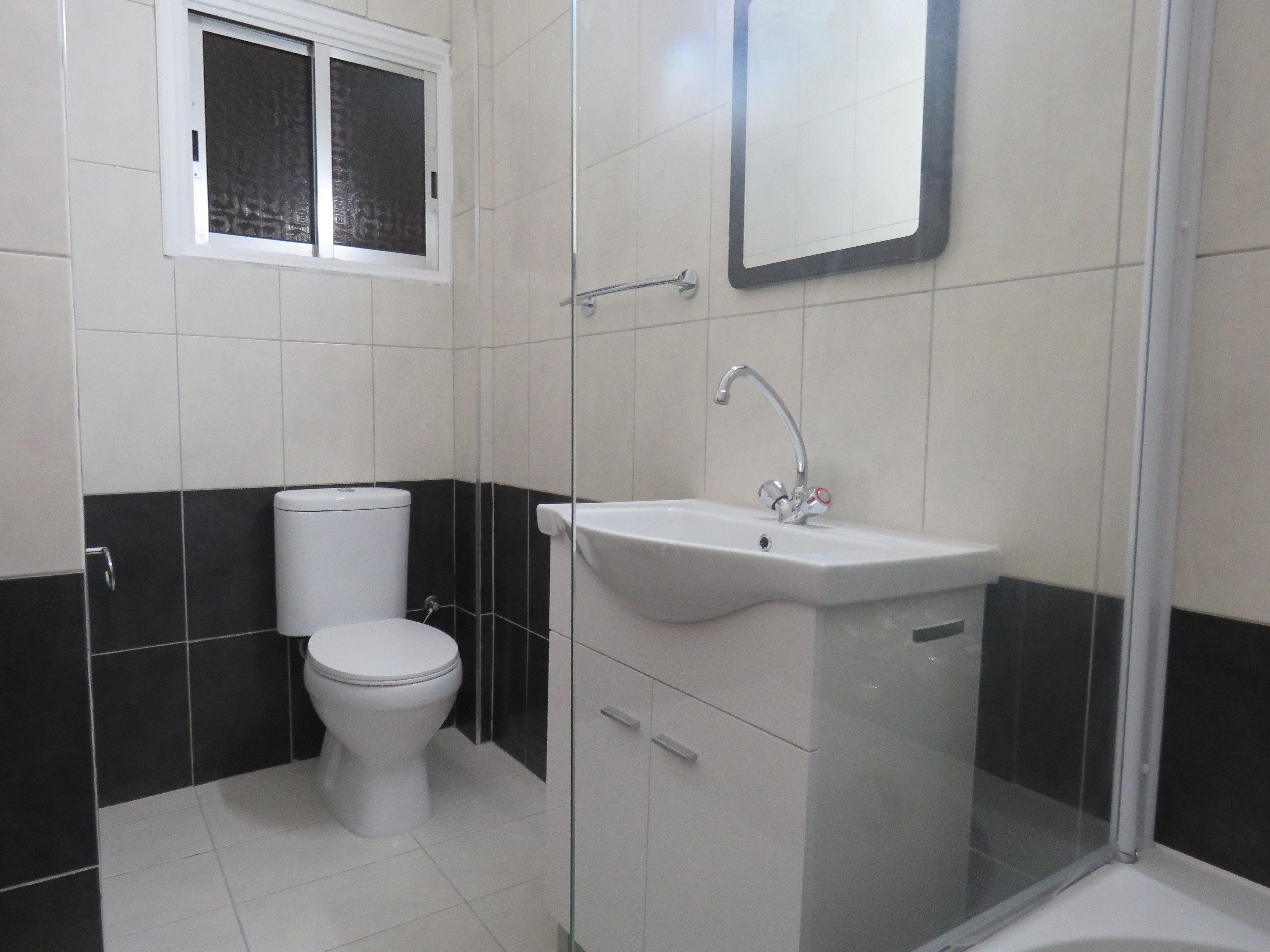 Ein Badezimmer mit Toilette, Waschbecken und Dusche.