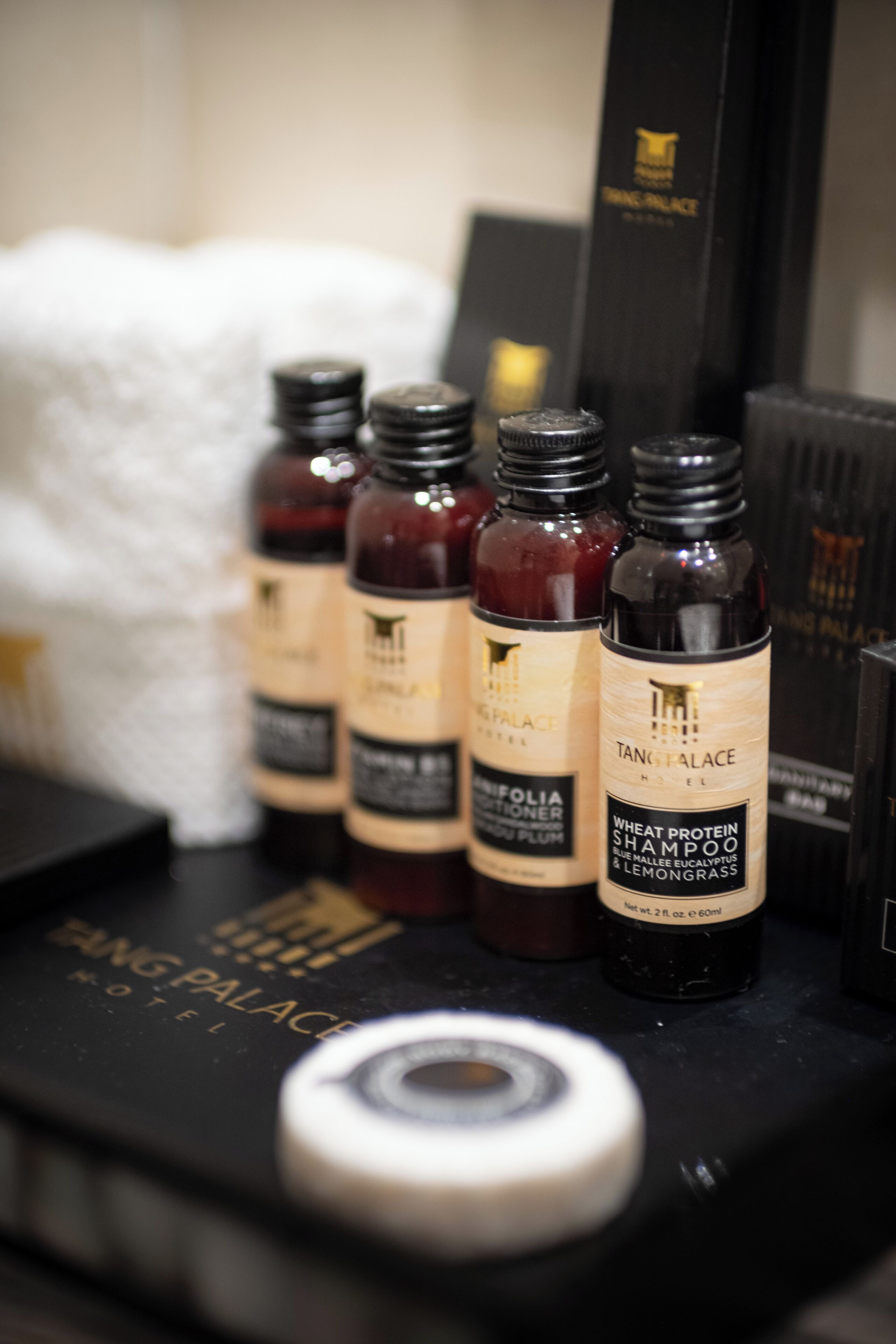Bottles of Tang Palace hotel shampoo on a shelf.