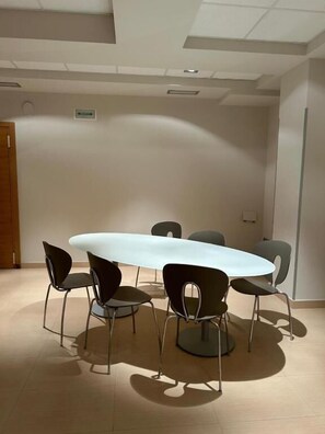 A conference room with a round table and six chairs.