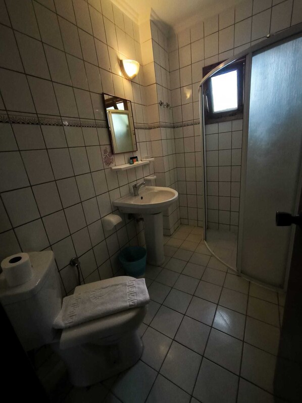 A small bathroom with a toilet, sink, and shower. - Naturella Apart Hotel (Kemer)