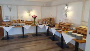 A buffet setup with multiple serving stations, clear glass containers, and a variety of food items. - Gasthaus Brauner Hirsch (Hann. Muenden)