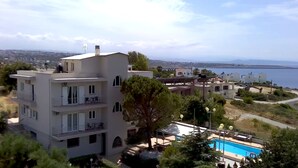 Un immeuble à plusieurs étages doté de balcons, d’une piscine et offrant une vue sur la mer.