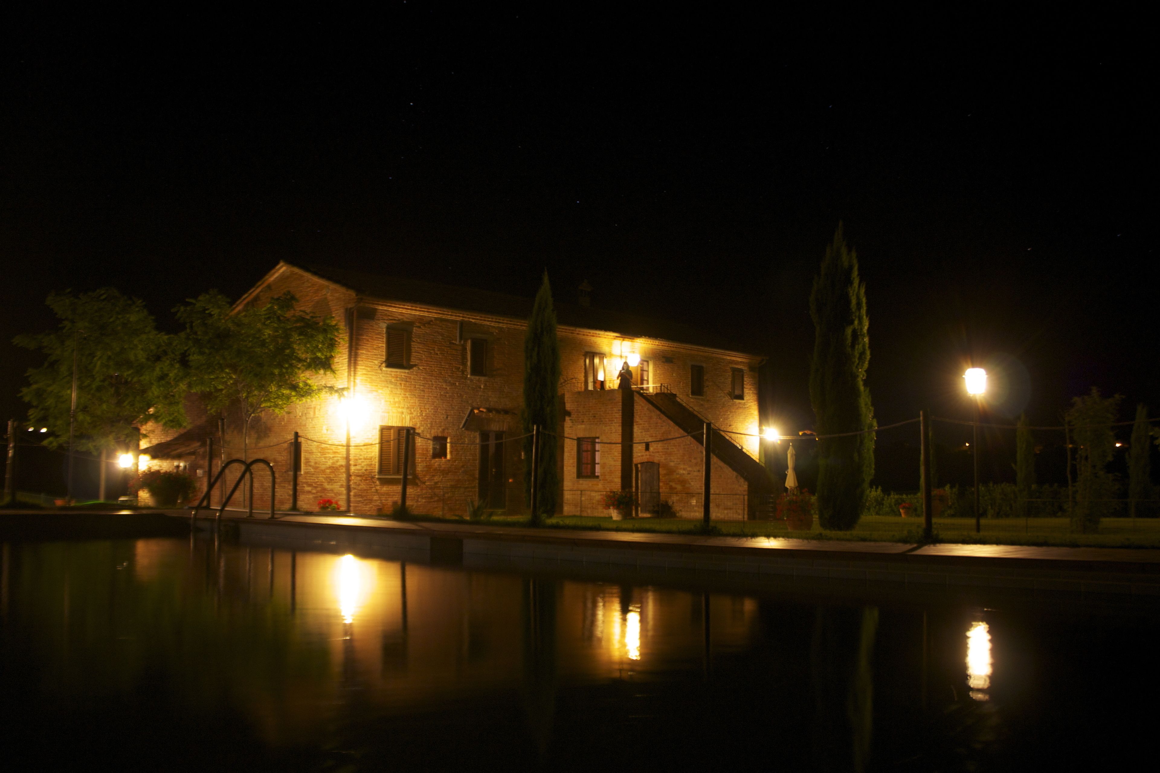 A brick building with a staircase and a pool in the foreground.