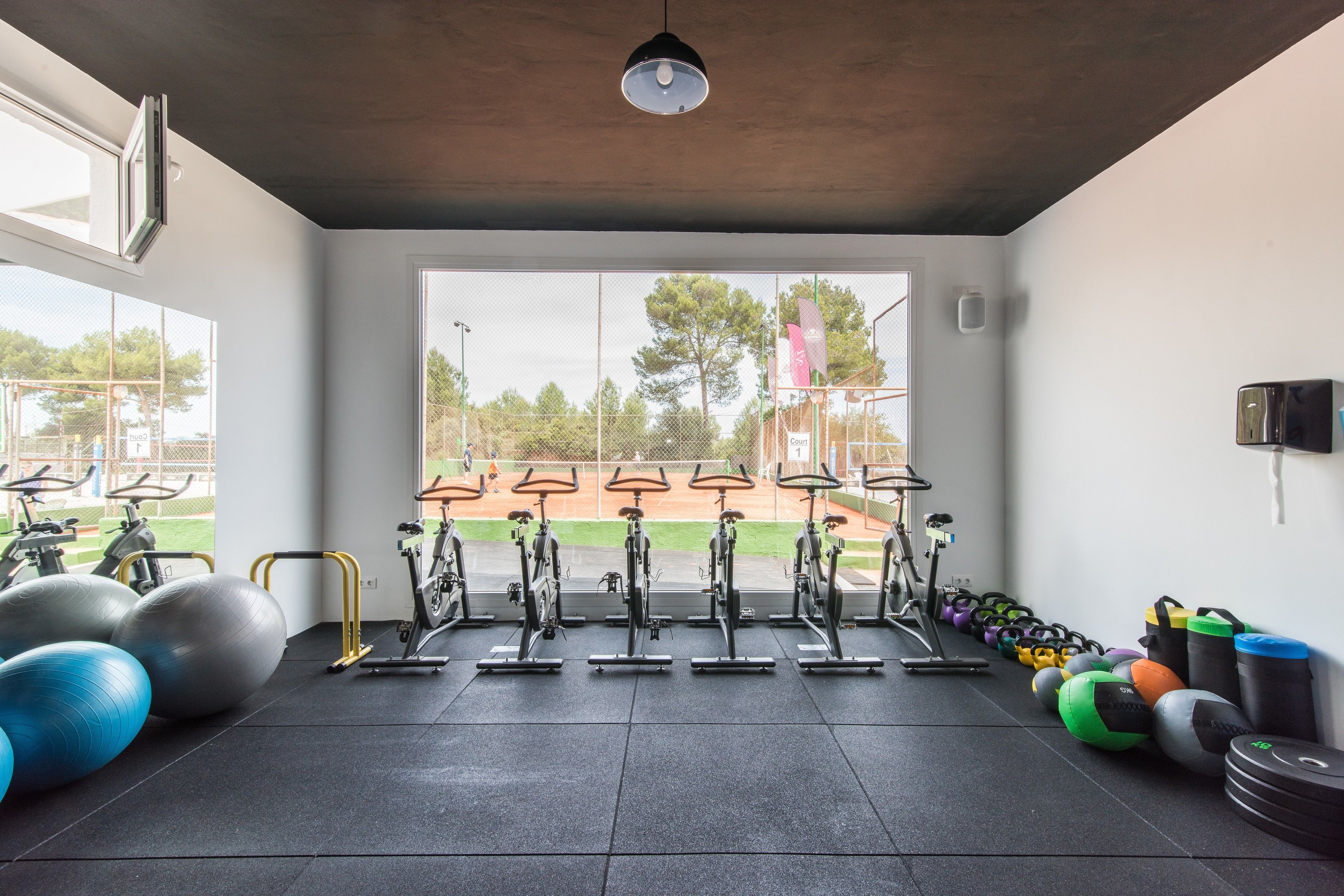 A gym with stationary bikes, exercise balls, and weights.