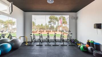 A gym with stationary bikes, exercise balls, and weights.