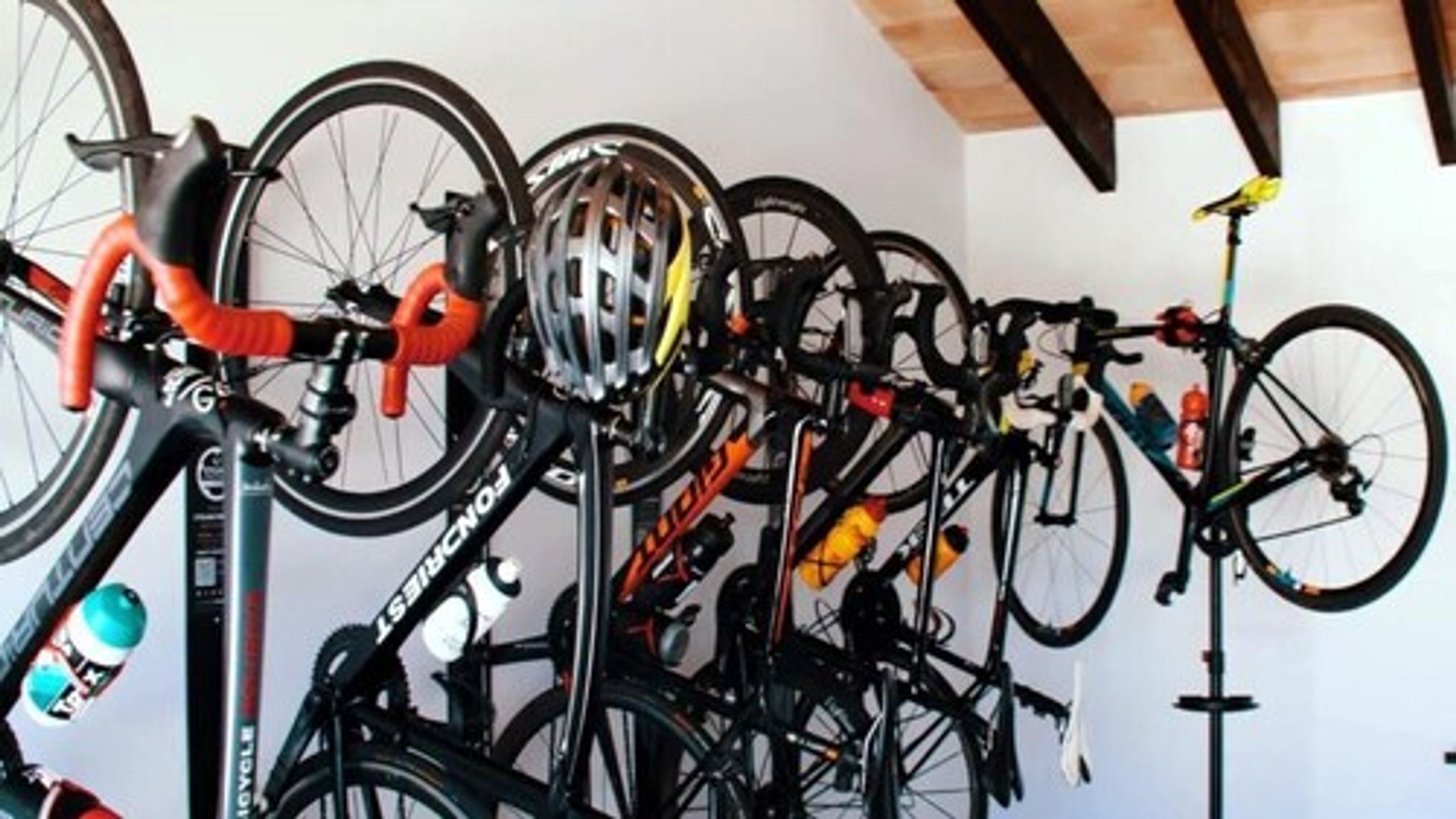 Un perchero para bicicletas instalado en la pared, con varias bicicletas.