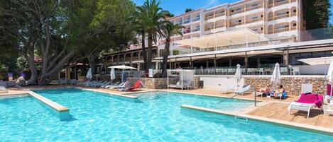 Una piscina al aire libre, sillones reclinables de piscina