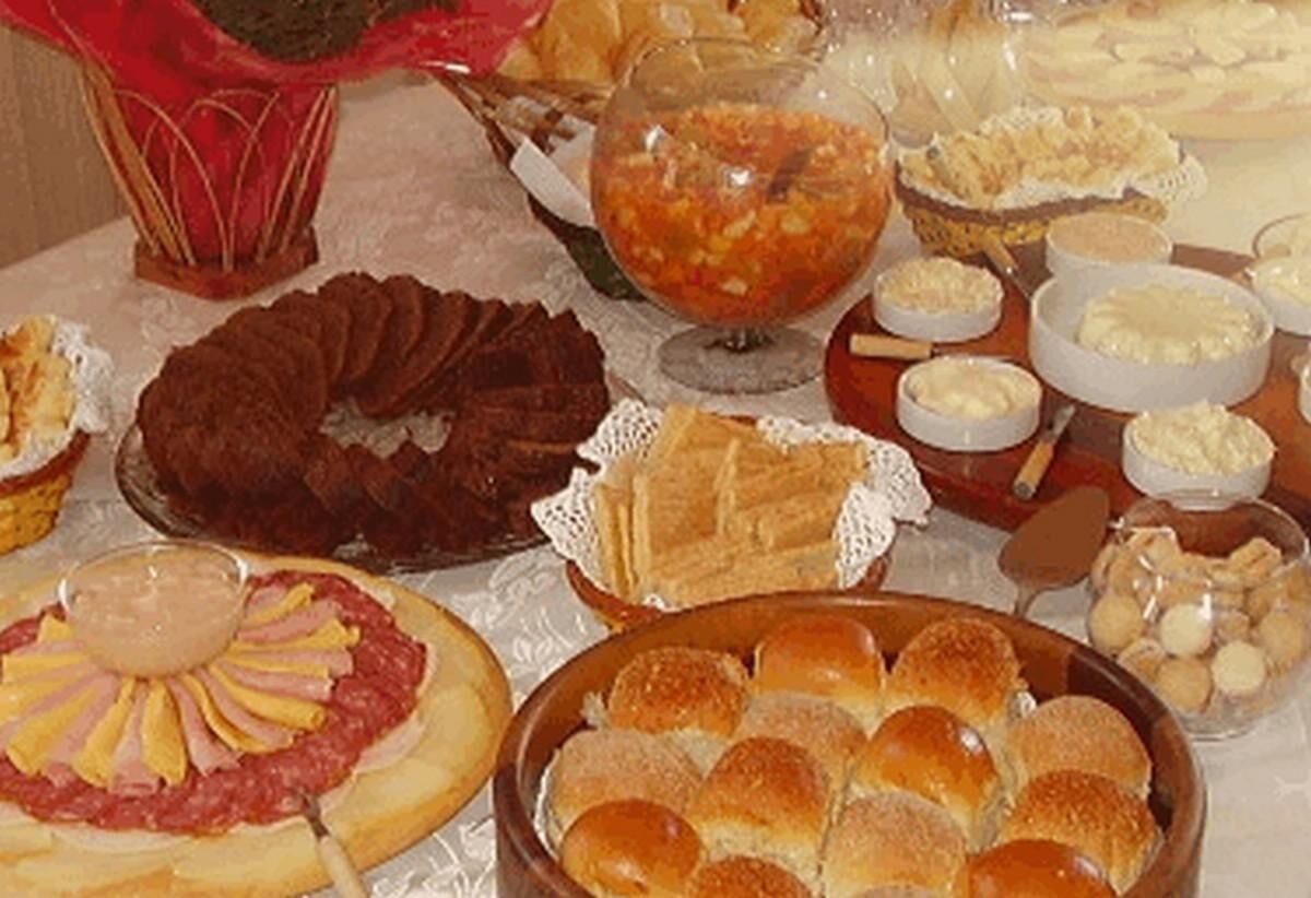 A table with various food items including a cake, pastries, and a bowl of soup.