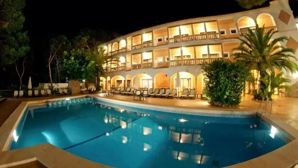 A hotel with a swimming pool, multiple balconies, and outdoor seating areas. - Cala Gat (Capdepera)
