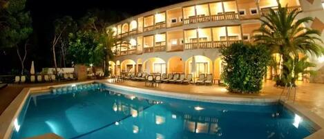 Una piscina al aire libre, tumbonas