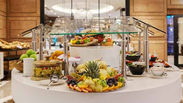 Um buffet com frutas, legumes e pão variados.