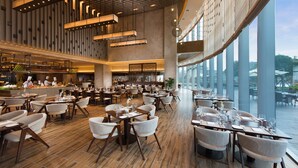A spacious restaurant with high ceilings, modern lighting, and large windows offering views of the outdoors. - DoubleTree by Hilton Hotel Anshun (Anshun)
