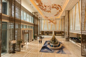 A spacious lobby with a central fountain, high ceilings, and modern decor.