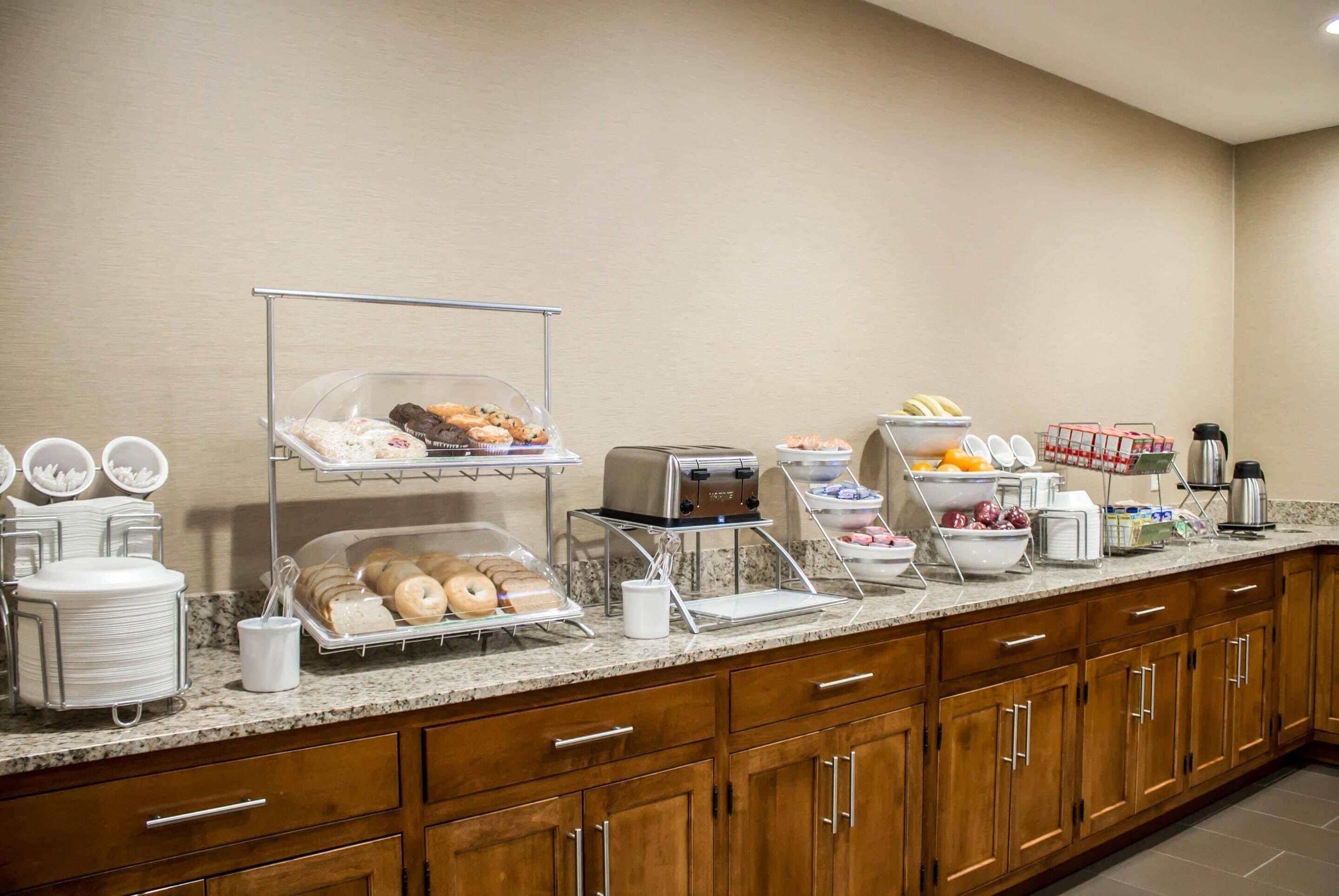 A breakfast buffet setup with various food items and a coffee station.