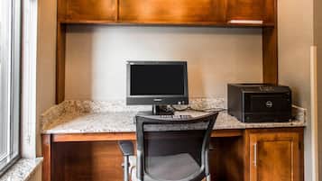 A kitchen with a granite countertop, a black computer monitor, and a printer.