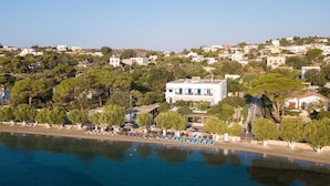 A coastal hotel with a pool area, surrounded by trees and other buildings. - Alinda Hotel (Leros)