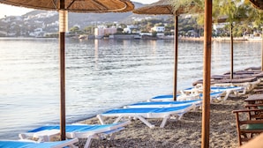 A beach with thatched umbrellas and sun loungers. - Alinda Hotel (Leros)