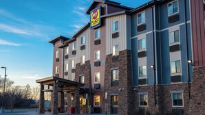 Un hotel de varios pisos con un letrero que dice 'My Place', con una fachada de ladrillo y revestimiento, numerosas ventanas y un área de entrada cubierta.