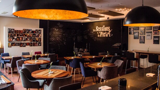 A restaurant interior with round tables, chairs, and pendant lighting. - Le Pietri Urban Hotel (Rabat)
