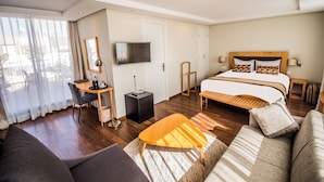 A hotel room with a bed, a desk, a chair, a TV, and a sofa. - Le Pietri Urban Hotel (Rabat)