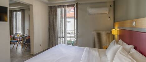 A hotel room with a bed, a desk, and a chair.