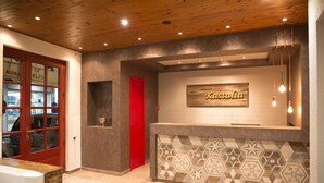 A reception area with a wooden ceiling, a red door, and a wall-mounted sign that reads "Kastalia." - Kastalia Boutique Hotel (Delphi)