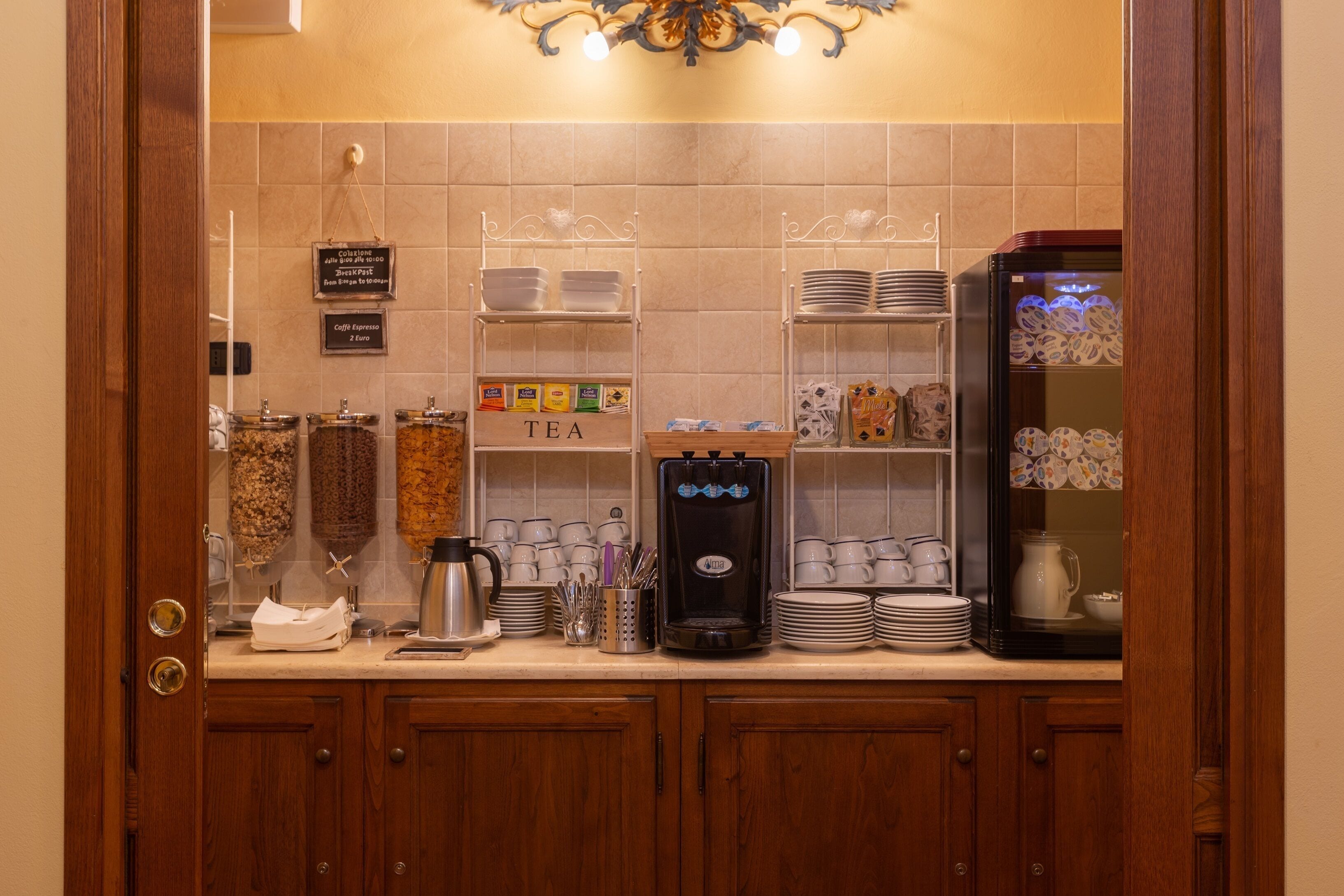 A kitchenette with a coffee machine, tea station, and various kitchen utensils.