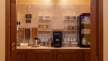 Een kitchenette met een koffiezetapparaat, theefaciliteiten en diverse keukengerei.
