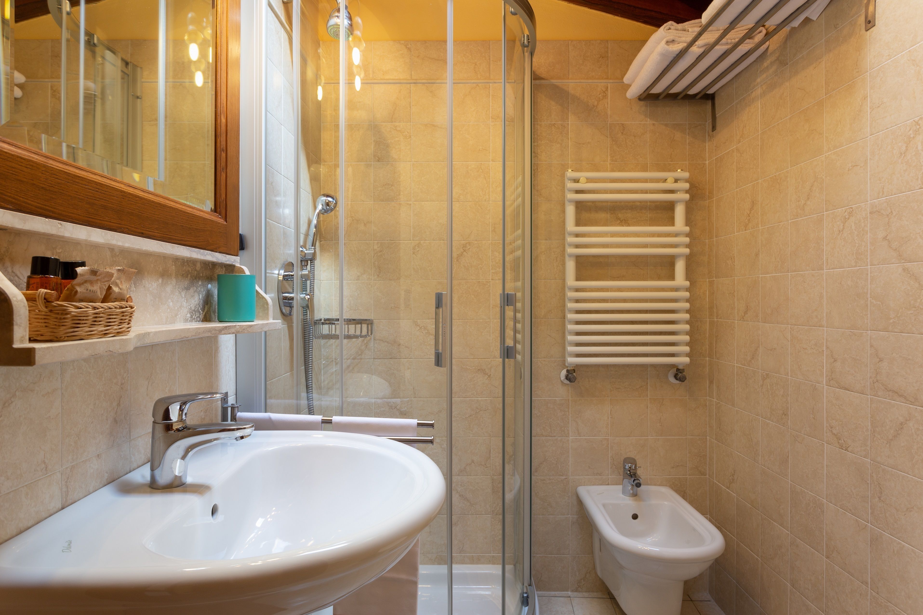 A bathroom with a sink, bidet, and glass shower enclosure.