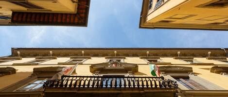 A building with a balcony, multiple windows, and a clear sky.