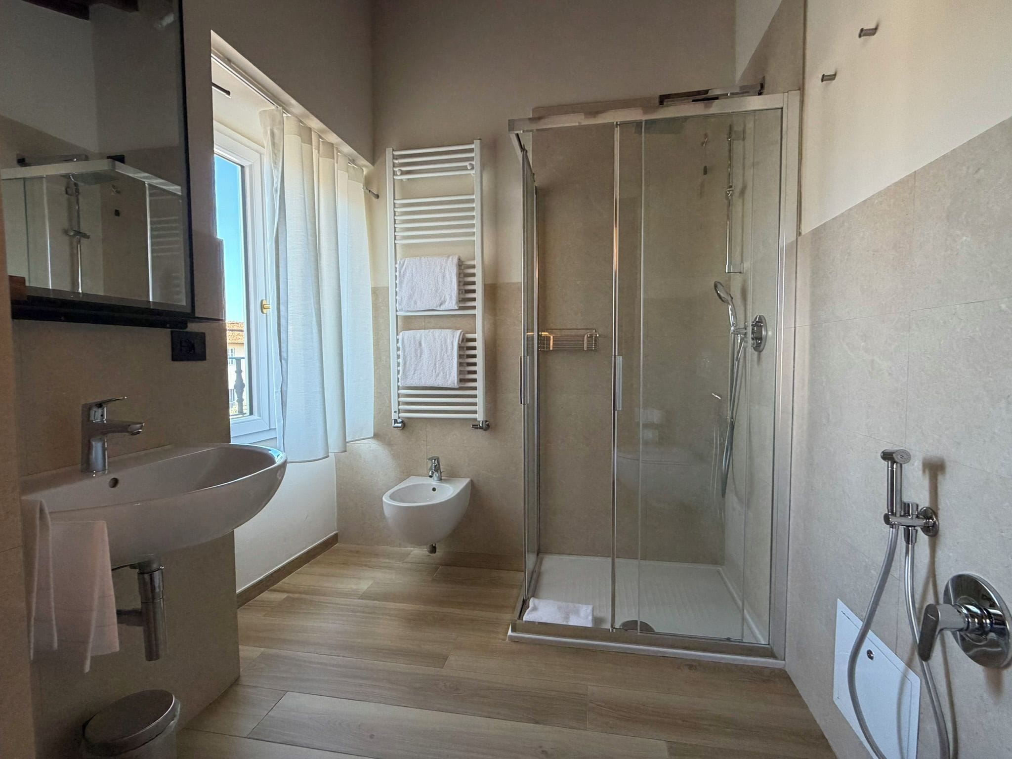 Une salle de bain moderne avec une douche à parois de verre, un lavabo et un bidet.
