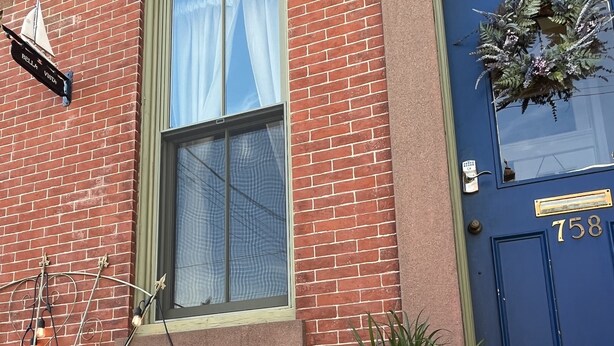 Un edificio de ladrillo con una puerta azul marcada