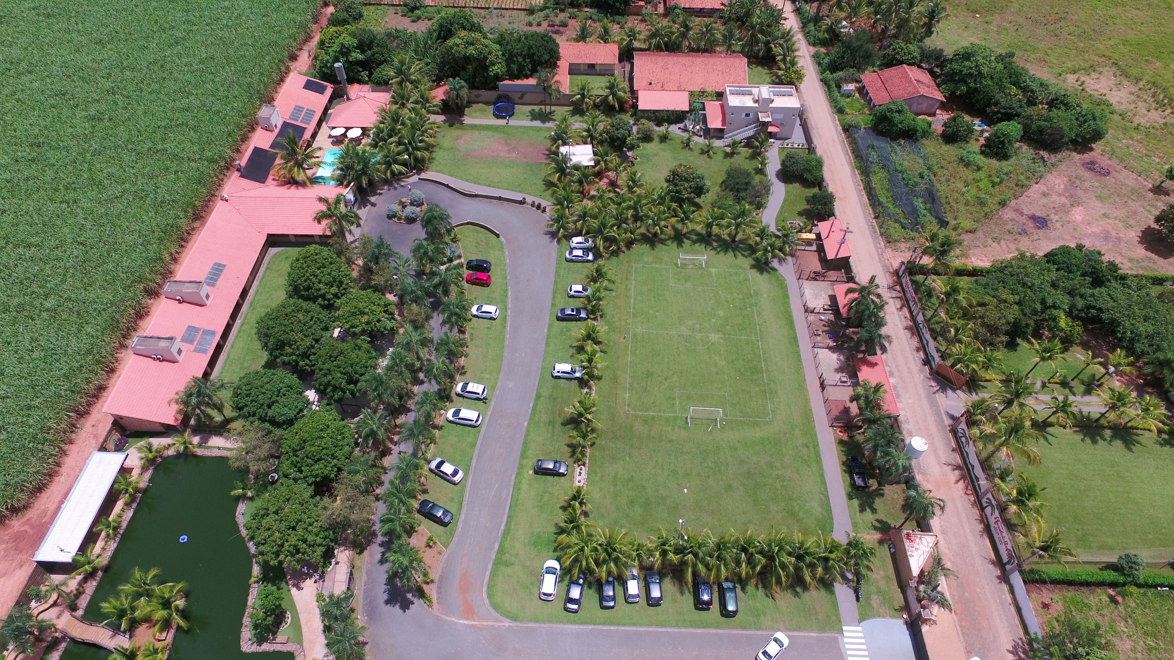 Vista aérea de una zona residencial con casas, una piscina y un estacionamiento.