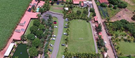 Vista aérea de una zona residencial con casas, una piscina y un estacionamiento.