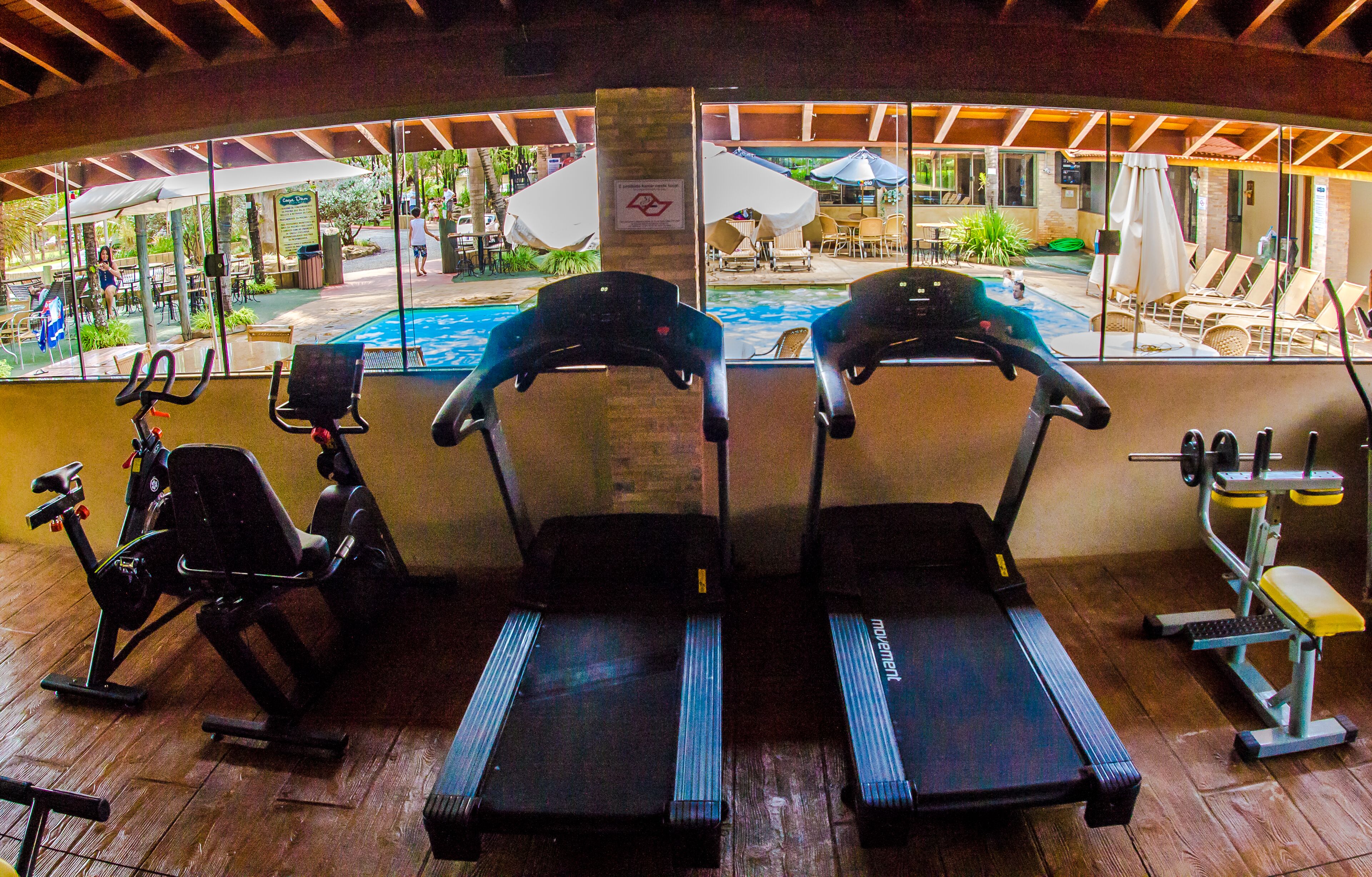 Une salle de sport intérieure équipée de tapis de course, de vélos d’appartement et d’appareils de musculation.