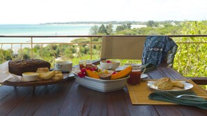 Ein Tisch mit Frühstücksangeboten und Blick aufs Meer.