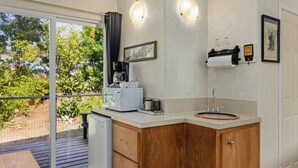 Una cocina con microondas, cafetera y lavabo.