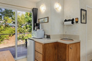 A kitchen with a microwave, coffee maker, and sink.