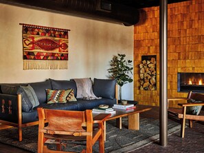 A cozy living room with a sofa, coffee table, and a fireplace.